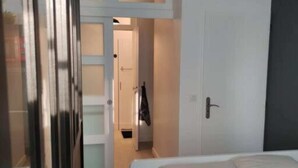 Ein Schlafzimmer mit einem Bett, einem Kleiderschrank und einer Tür zu einem Badezimmer.