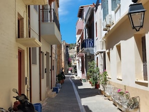 A narrow street lined with buildings, some with balconies and potted plants. - Fortezza Nest - Old Town Rethymno (Rethymno)