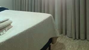 Une chambre d’hôtel avec un lit, des rideaux et une fenêtre.