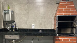 Une cuisine équipée d’une cuisinière à gaz, d’un distributeur d’eau et d’un four à briques.