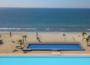 Relax by the oceanfront pool overlooking the calm sea.