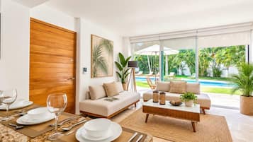 Un salon moderne avec un canapé, une table basse et un coin repas aménagé pour prendre un repas.