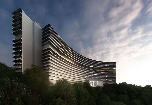 A modern building with a curved facade, large windows, and a flat roof.