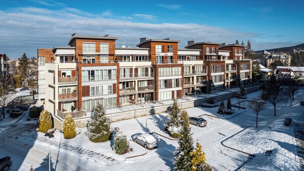 Un immeuble résidentiel à plusieurs étages, doté de balcons et de grandes fenêtres.