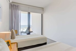 Une chambre d’hôtel moderne dotée d’un grand lit, d’un bureau et offrant une vue sur l’extérieur.