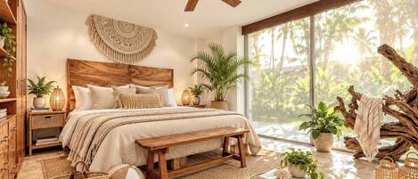 A bedroom with a wooden headboard, a large bed, a bench, a bedside table, a floor lamp, and a view of palm trees through a large window.