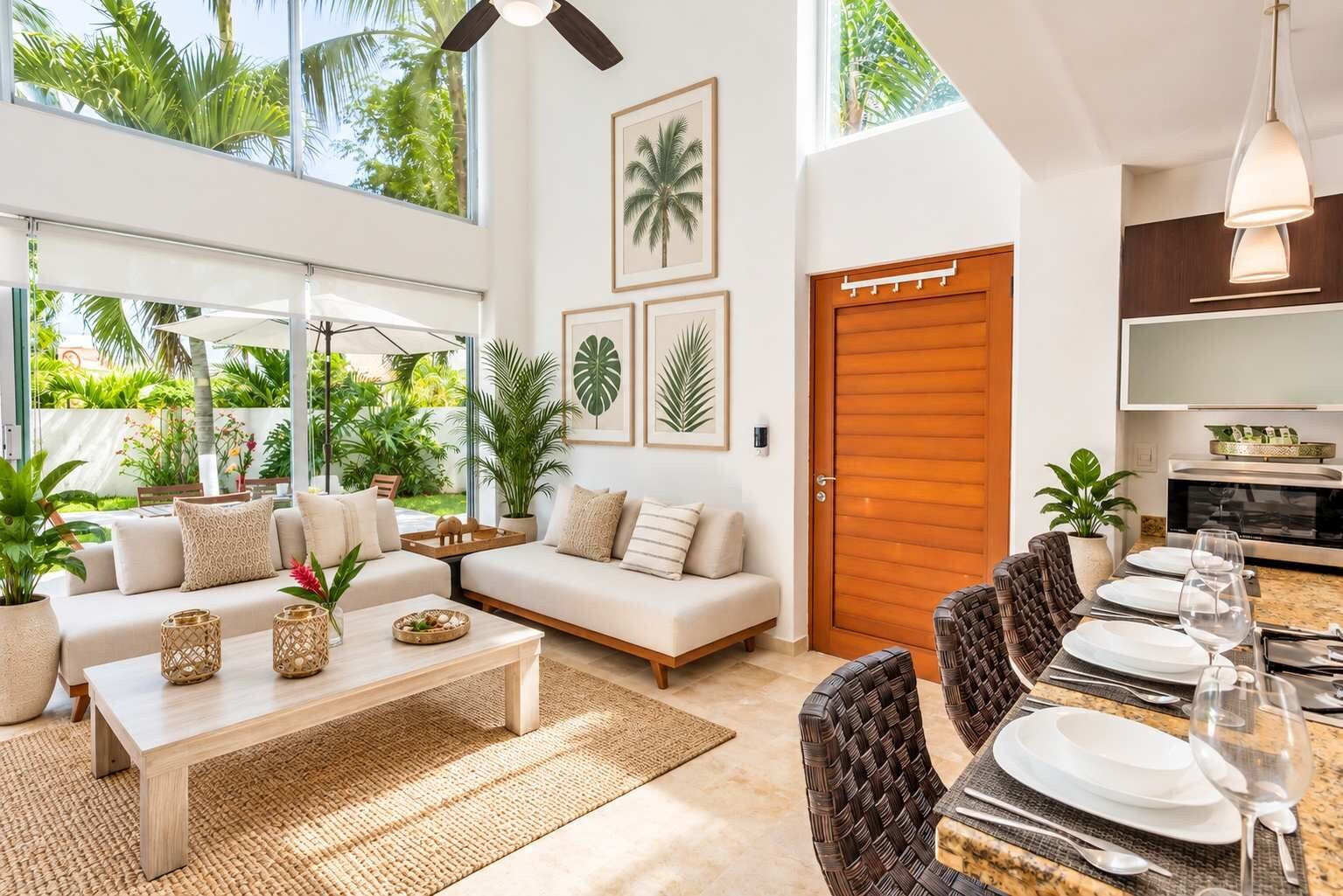 A modern living room with a sofa, coffee table, and dining area with chairs and a table set for a meal.