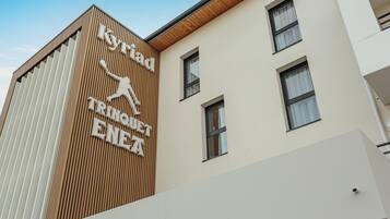Un edificio con un cartel que dice "Kyriad Trinquet ENEA".