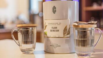 Servizio da tè comprendente una teiera e due bicchieri di vetro, con un'etichetta che riporta 'FUJIAN BAI MU DAN' e 'THÉ BLANC DE CHINE - BIO'.