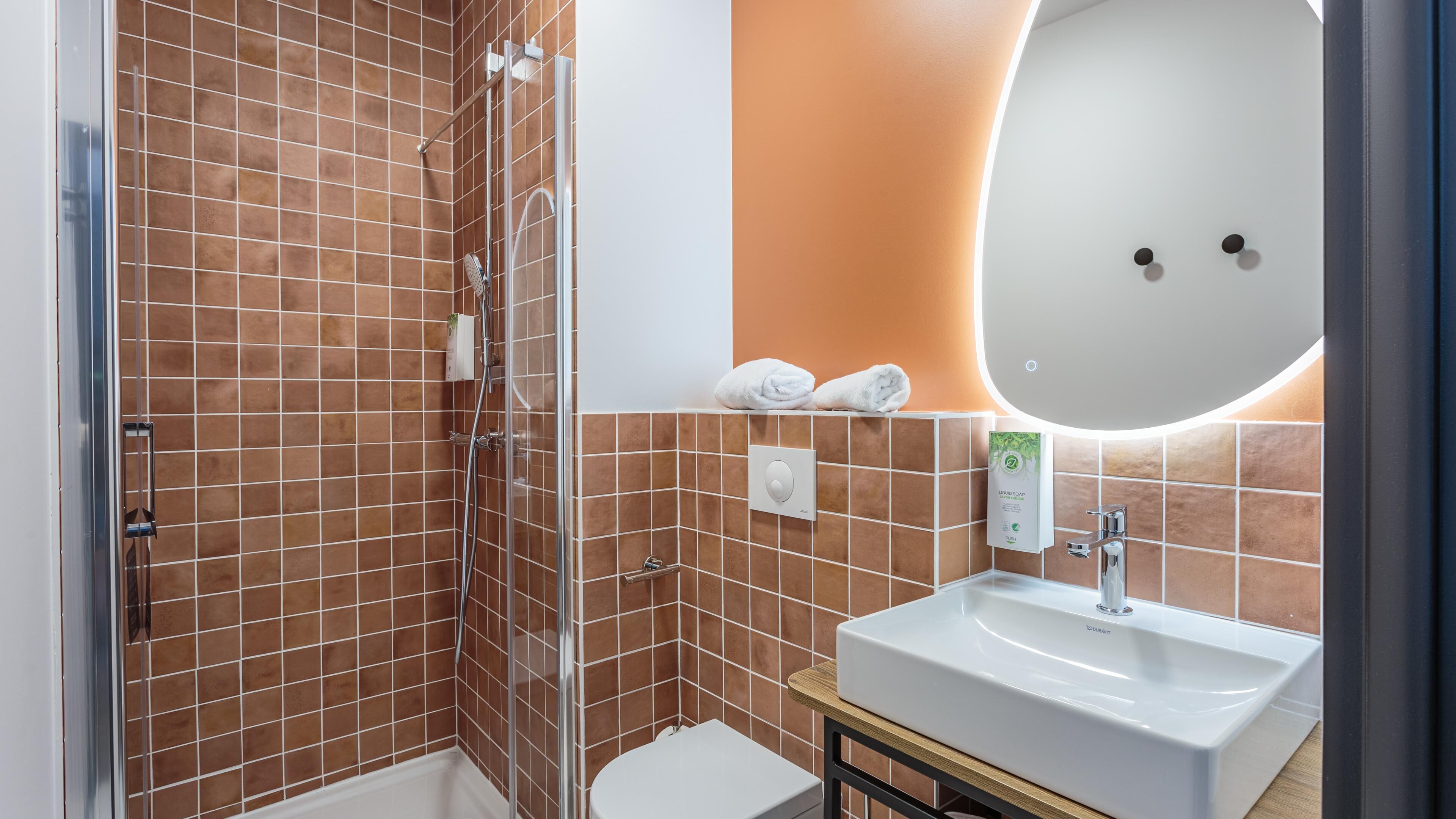 A bathroom with a shower, toilet, and sink.