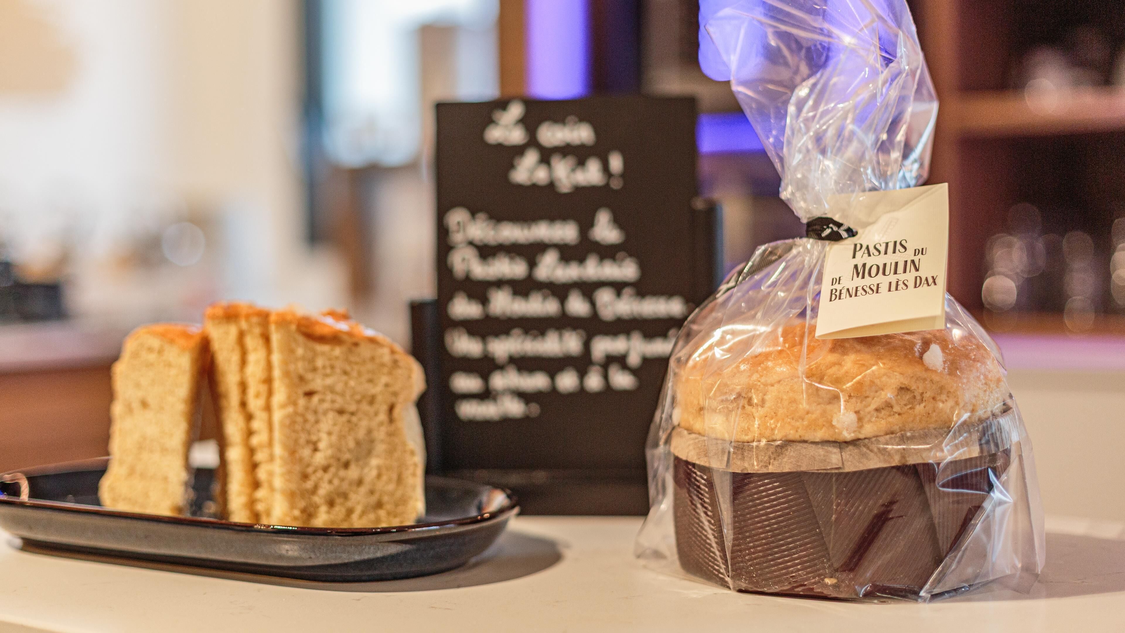 A loaf of bread with a label and a plate with two slices of bread.