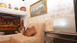 A room with a bed, a painting, and a stove. - Gioma Stone House by Checkin (Heraklion)