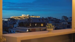 A view of a historic building on a hill with modern buildings in the foreground.