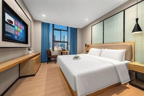 A hotel room with a large bed, a desk with a computer, a TV mounted on the wall, and a window with curtains. - Langyi Hotel (Guangzhou Tower Pazhou Exhibition Center Branch) (Guangzhou)