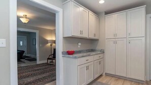 A kitchen with white cabinets, a marble countertop, and a red bowl on the counter. - Pet-Friendly Home Near IU Campus (Bloomington)