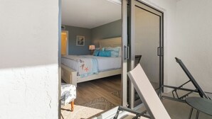 Una camera da letto con un letto, un comodino, una lampada e una sedia.