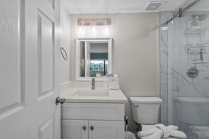 Een moderne badkamer met een wastafel, toilet en douche.