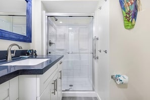 A bathroom with a shower, a sink, and a toilet.