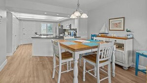 A spacious kitchen with a central island, white cabinetry, and a blue accent wall.