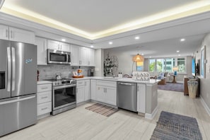 A modern kitchen with stainless steel appliances, white cabinetry, and a central island.