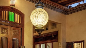 Un intérieur traditionnel avec un escalier, une porte en bois et un sol à motifs.