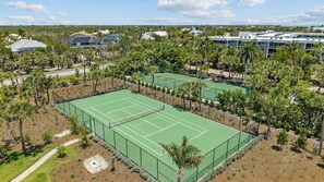 Un court de tennis entouré d’arbres et d’immeubles.