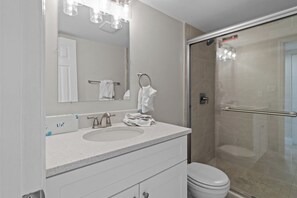 A modern bathroom with a sink, mirror, and toilet.