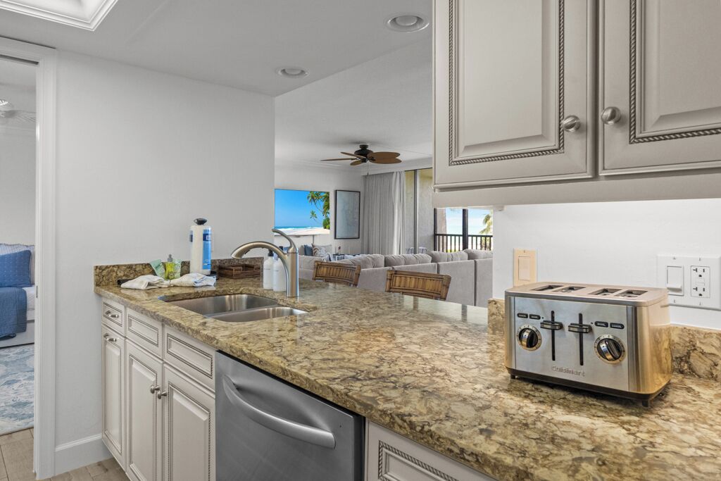 A kitchen with granite countertops, stainless steel appliances, and a built-in toaster.