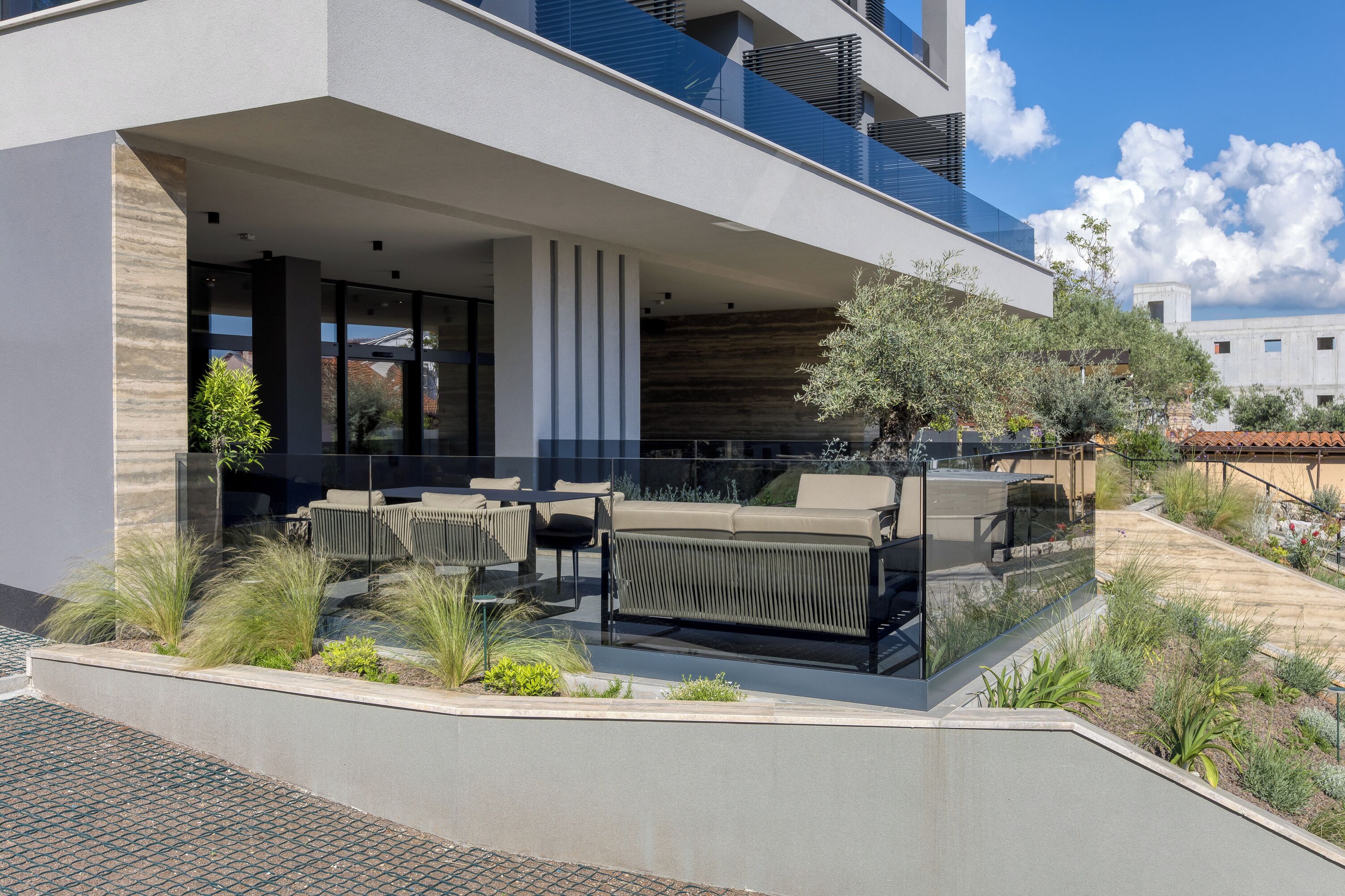 A modern outdoor patio with a sofa, chairs, and a dining table.