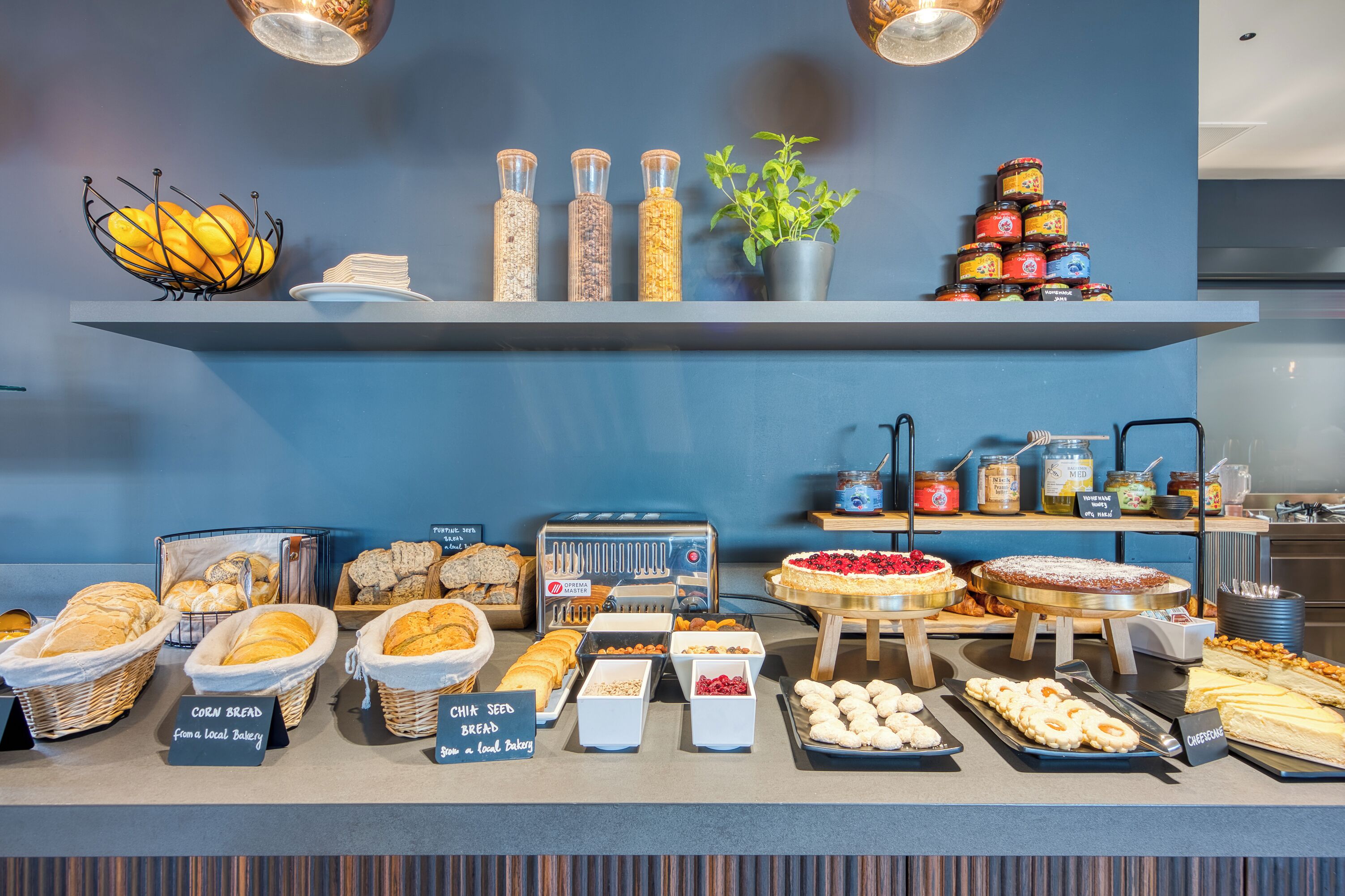 Un bufé de desayuno con panes, pasteles y salsas diversas.