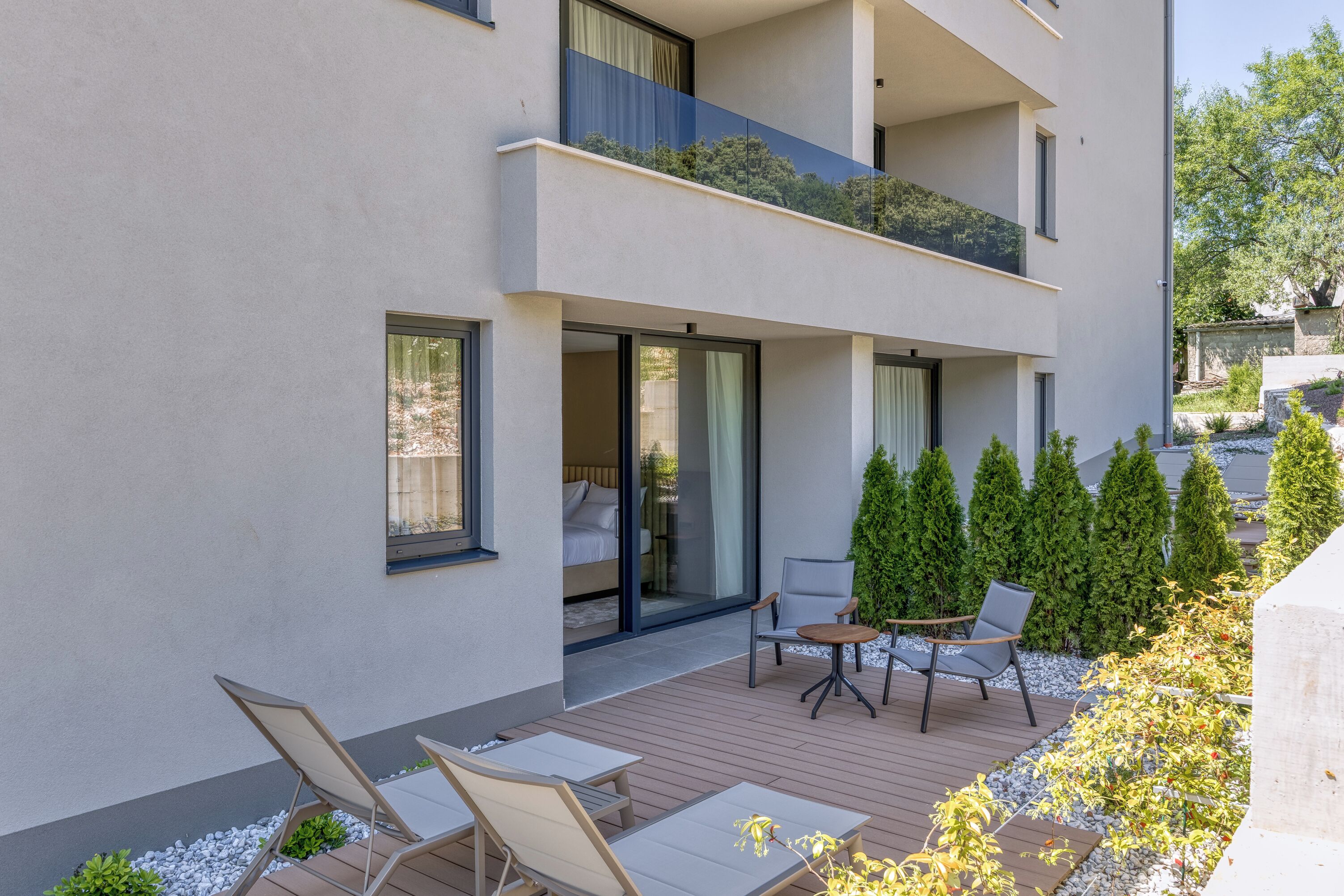 Eine moderne Wohnung mit Balkon, Sitzgelegenheit im Freien und Garten.