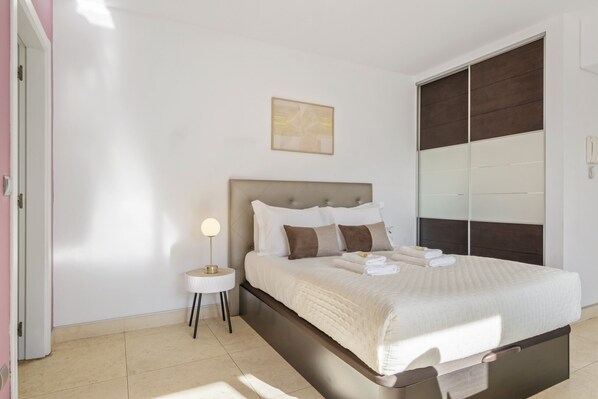 Une chambre à coucher avec un lit, une table de chevet et une armoire.