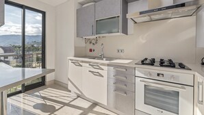 Eine moderne Küche mit großem Fenster, einem Einbauofen und einem Gasherd.