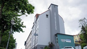 Un edificio de hotel con diseño moderno, que destaca un cartel en la fachada.