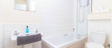 Une salle de bain moderne avec un lavabo blanc, une baignoire et des toilettes.