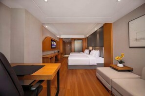 A hotel room with a bed, a desk, a chair, a sofa, and a TV. - Zhengzhou Bolui Hotel (Erqi Square David City) (Zhengzhou)