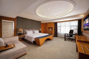 A modern hotel room with a bed, a desk, a chair, a sofa, and a TV. - Zhengzhou Bolui Hotel (Erqi Square David City) (Zhengzhou)