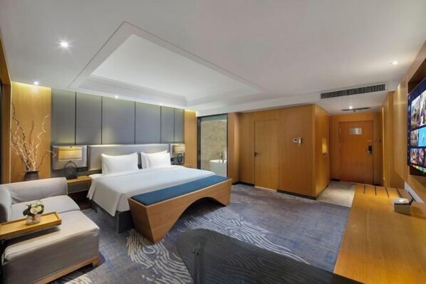 A modern hotel room with a large bed, a sofa, a desk, and a TV. - Zhengzhou Bolui Hotel (Erqi Square David City) (Zhengzhou)