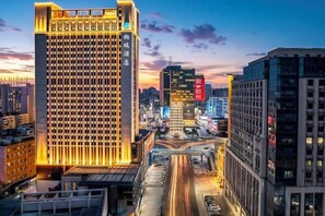A high-rise hotel with a grid-like facade, surrounded by other buildings and a busy street. - Zhengzhou Bolui Hotel (Erqi Square David City) (Zhengzhou)