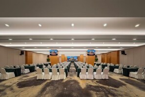 A conference room with rows of tables and chairs, a carpeted floor, and a high ceiling with recessed lighting. - Zhengzhou Bolui Hotel (Erqi Square David City) (Zhengzhou)