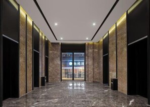 A modern lobby with a marble floor, black walls, and a glass door leading to a shop. - Zhengzhou Bolui Hotel (Erqi Square David City) (Zhengzhou)