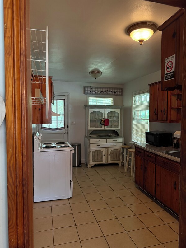 A kitchen with a stove, cabinets, and a microwave.