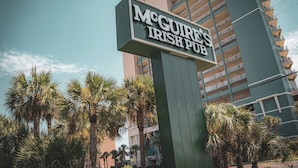 A sign for McGure's Irish Pub with a modern building in the background.