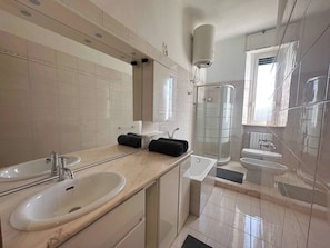 Een douche, een haardroger, een bidet, handdoeken