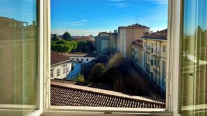 A view from a window overlooking a cityscape with buildings and a clear sky.