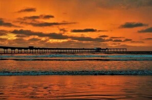 A pier extending into the water during sunset.