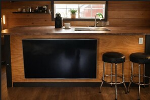 A kitchen with a wooden countertop, a black sink, and two black stools. - Charming "Melrose Place" w Year-Round Heated Pool, Deck & Grill (Victoria)