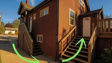A two-story house with a front porch, a staircase, and a welcome sign.