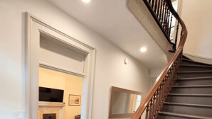 A staircase with wooden railings and a handrail, leading to an upper floor.