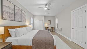 A bedroom with a bed, a desk, a chair, and a ceiling fan. - Washington Park Retreat | Free Parking | OTR (Cincinnati)